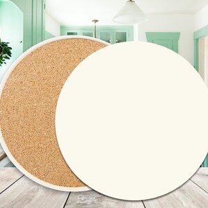 May include: A round, white ceramic coaster with a cork backing. The coaster is shown on a wooden surface.