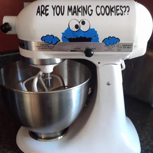 May include: White stand mixer with a blue cookie monster sticker that says "Are you making cookies?"