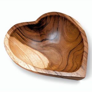 May include: A heart-shaped wooden bowl featuring a natural grain pattern with varying shades of brown, ranging from light tan to deep dark brown. The bowl has a smooth, polished interior surface and a thick, sturdy rim following the heart contour.