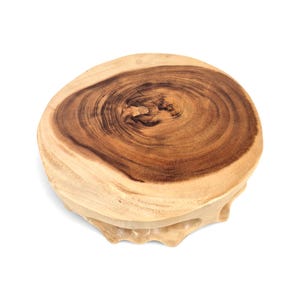 May include: A circular wooden stand featuring a natural live edge and a prominent dark brown wood grain pattern in the center. The base is carved from a single piece of wood with an irregular, organic shape and a smooth, polished finish.