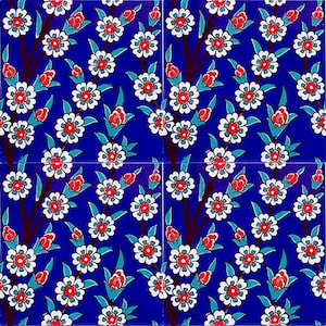 Puede incluir: Un patrón repetitivo de flores blancas con centros rojos sobre un fondo azul. Las flores son estilizadas y tienen un diseño turco tradicional.