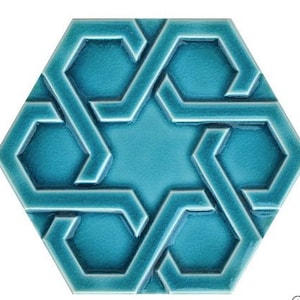Puede incluir: Un azulejo hexagonal de cerámica azul turquesa con un patrón geométrico de formas entrelazadas. El azulejo tiene un diseño en relieve y un acabado brillante.