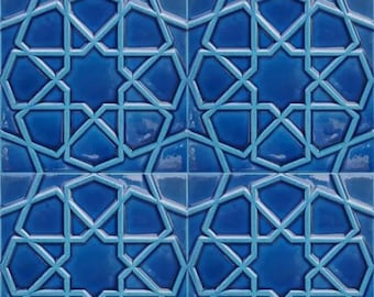 Op de afbeelding: Een blauwe en witte keramische tegel met een geometrisch patroon. De tegel heeft een reliëfdesign en een glanzende afwerking.