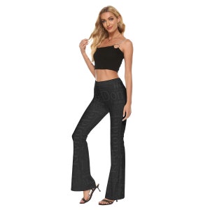 May include: Black flared pants with a print of words in a light gray color. The pants have a high waist and a fitted silhouette.