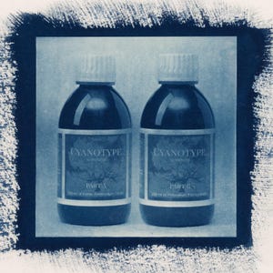 May include: Two dark blue bottles of cyanotype sensitizer, labeled "Part A" and "Part B." Each bottle contains 250 ml of liquid. The labels feature the text "CYANOTYPE" and a tree illustration.