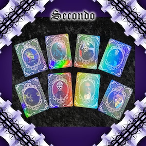 May include: Seven playing cards with holographic, iridescent surfaces. Each card features a portrait of a figure in a decorative frame. The word "Secondo" is at the top. The cards are arranged on a dark surface with a purple and white decorative border.