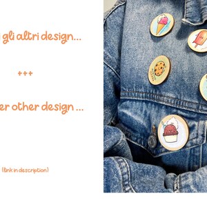 Op de afbeelding: Een spijkerjack met vijf verschillende pinnen eraan bevestigd. De pinnen zijn allemaal rond en hebben verschillende cartoonfiguren en ontwerpen. De pinnen zijn allemaal in verschillende kleuren en hebben een witte achtergrond. De tekst op de pinnen luidt "You complete me" en "You're my favorite."