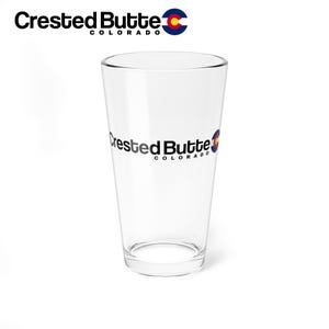 Puede incluir: Un vaso de pinta de vidrio transparente con el texto "Crested Butte Colorado" y una imagen estilizada de la bandera del estado de Colorado.