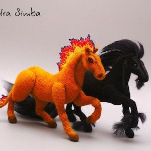 May include: Two crocheted horses, one orange with a fiery mane and tail, the other black with a long mane and tail.  Alexandra Simba is written in black ink at the top of the image.