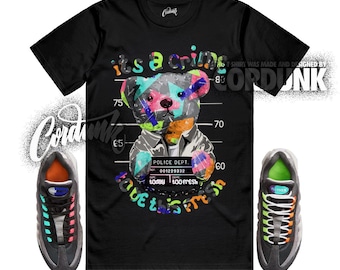 Peut inclure: T-shirt noir avec un graphisme coloré d'un ours en peluche dans un alignement policier, avec le texte "its a crime" et "love this fresh". Des baskets grises et noires avec des accents colorés sont de chaque côté.