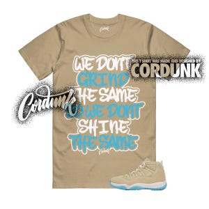 May include: Tan t-shirt with the text "WE DON'T GRIND THE SAME, WE DON'T SHINE THE SAME" in white and blue. A pair of tan and blue sneakers is at the bottom. The shirt is designed by Cordunk.