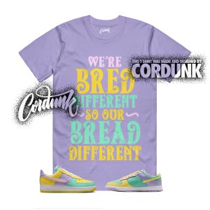 May include: A lilac t-shirt with the text "WE'RE BRED DIFFERENT SO OUR BREAD DIFFERENT" in yellow, green, and pink. Below the shirt are two pairs of colorful sneakers with yellow, green, and purple accents. The brand name "Cordunk" is visible.