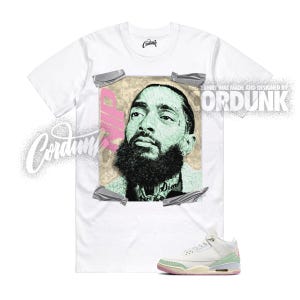 May include: White t-shirt featuring a portrait of a man with a black beard and the word "Dior" on his neck. The shirt is paired with white and light green sneakers. The text "CORDUNK" is printed on the shirt.