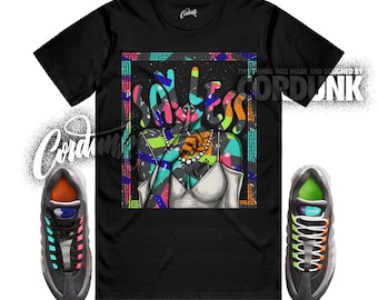 Peut inclure: T-shirt noir avec un graphisme coloré représentant un torse féminin et le mot "SOULESS" en style graffiti. Le t-shirt est associé à des baskets grises et noires avec des accents orange et verts. Le texte "THIS T SHIRT WAS MADE AND DESIGNED BY CORDUNK" est visible.