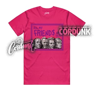 May include: A magenta t-shirt with a graphic design featuring the text "ALL MY FRIENDS ARE DEAD" and images of historical figures. The shirt also includes the text "THIS T SHIRT WAS MADE AND DESIGNED BY CORDUNK".
