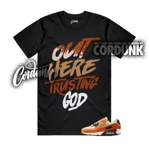 May include: Black t-shirt with the text "OUT HERE TRUSTING GOD" in brown, tan, and white. The shirt also features the Cordunk logo and a pair of orange and tan sneakers.