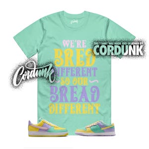 May include: A mint green t-shirt with the text "WE'RE BRED DIFFERENT SO OUR BREAD DIFFERENT" in yellow, purple, and pink. The shirt is paired with yellow, purple, and mint green sneakers. The brand name "CORDUNK" is also visible.