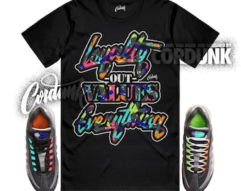 Peut inclure: T-shirt noir avec le texte "Loyalty Out Values Everything" dans un style graffiti coloré. L'image présente également une paire de baskets noires et grises avec des accents colorés.