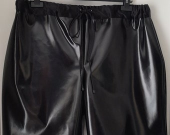A pair of black shiny PVC shorts with an elasticated drawstring waistband, size 34-36 inch waist.