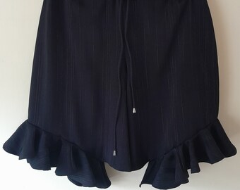 A pair of black shorts with silver thread stitch line detail and half width ruffles, size 34-38