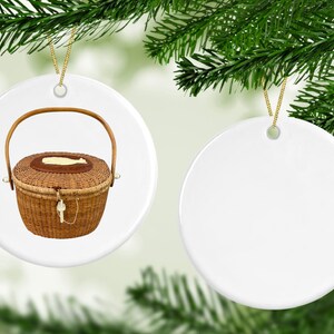 May include: Two white ceramic Christmas ornaments. One ornament features a brown wicker basket with a lid and a handle. The other ornament is blank.