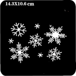 May include: A black stencil with a white snowflake design. The stencil measures 14.3 x 10.6 cm.