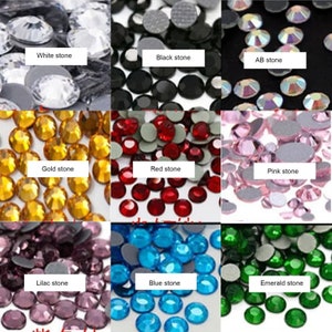 Puede incluir: Surtido de piedras de cristal de colores en varios colores, incluyendo blanco, negro, AB, dorado, rojo, rosa, lila, azul y esmeralda. Las piedras de cristal est&aacute;n dispuestas en filas sobre un fondo blanco.