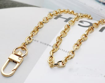 May include: A gold chain with a lobster clasp. The chain is made of metal and has a shiny finish.