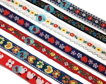 May include: Seven different colorful ribbon trims with various floral, heart, and animal designs. The ribbons are arranged in a vertical stack, with the top ribbon being black with white and red flowers, and the bottom ribbon being red with pink chicks.