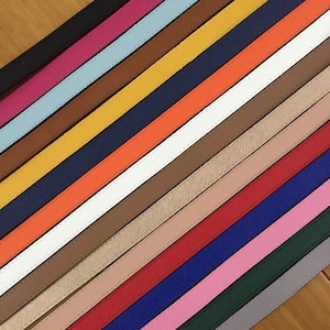 Puede incluir: Una colecci&oacute;n de 20 correas de cuero de diferentes colores, cada una con un sutil patr&oacute;n texturizado. Las correas est&aacute;n dispuestas en diagonal, con colores que van del negro al blanco.