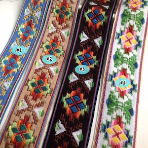 Könnte beinhalten: Vier verschiedene bestickte Besatzbänder mit geometrischen Mustern in verschiedenen Farben, darunter Blau, Rot, Grün, Gelb und Weiß. Die Bänder sind mit #1, #2, #3 und #4 gekennzeichnet.