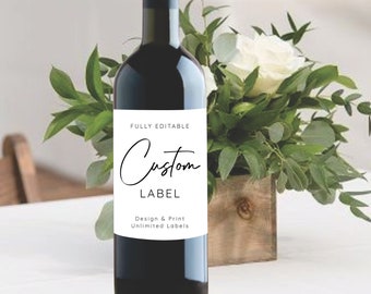 May include: A bottle of red wine with a white label that says "FULLY EDITABLE Custom LABEL Design & Print Unlimited Labels". The bottle is on a white table with a white flower arrangement in a wooden planter.