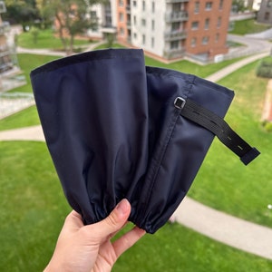 Può includere: Un paio di ghette impermeabili blu scuro con cinturino regolabile ed elastico in alto.
