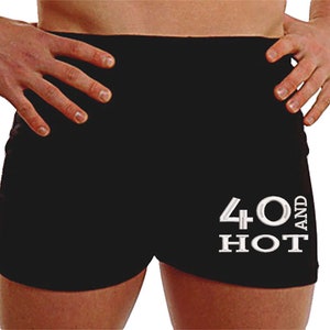 May include: Black athletic shorts with white text that reads "40 and HOT".