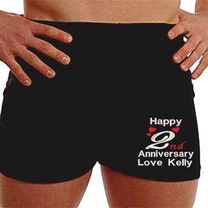 May include: Black boxer shorts with white text that reads "Happy 2nd Anniversary Love Kelly" with red hearts.