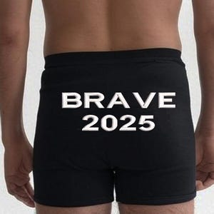 May include: Black boxer shorts with the word "BRAVE" and the number "2025" printed in white across the rear. The shorts are made of a soft material and have a comfortable fit.