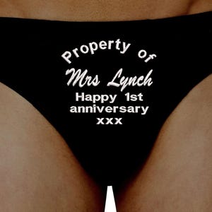 May include: Black underwear with white text reading "Property of Mrs Lynch Happy 1st anniversary xxx". The text is centered. The underwear is made of a soft material. A gift for a special occasion.
