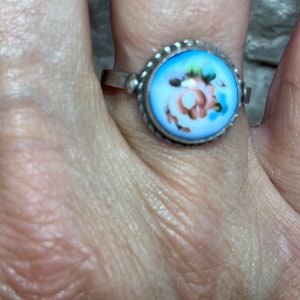 Peut inclure: Une bague en argent avec un cam&eacute;e en porcelaine bleu et blanc repr&eacute;sentant une rose rose.