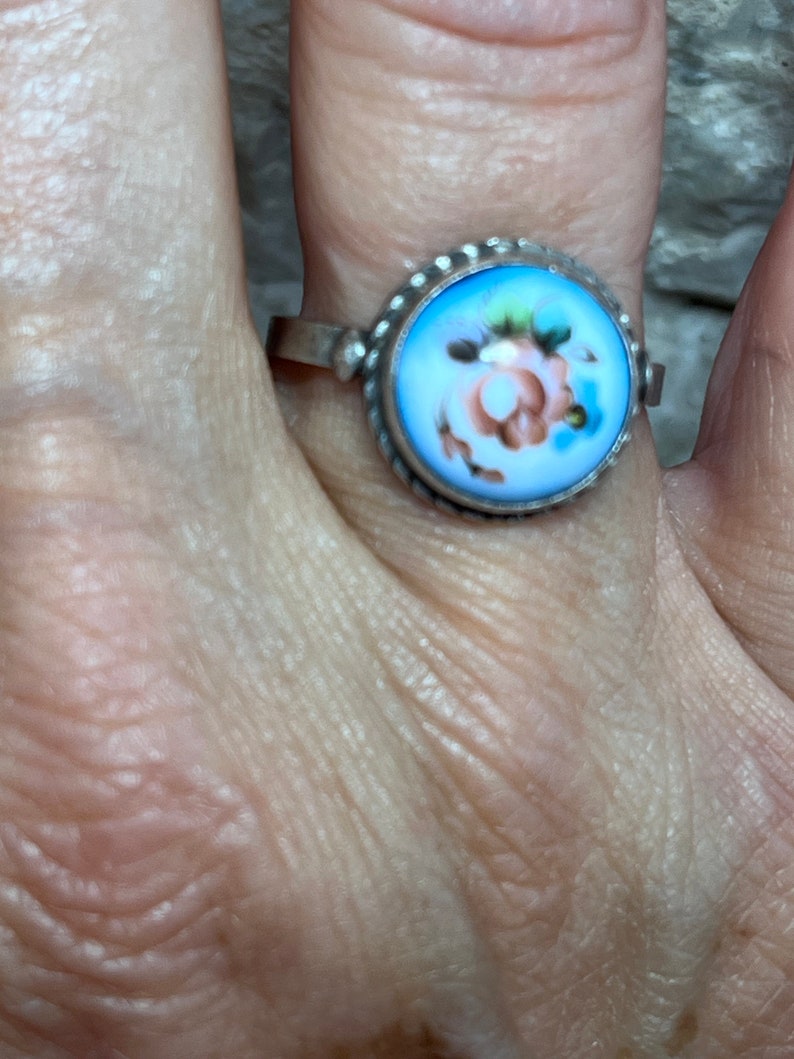 Peut inclure: Une bague en argent avec un cam&eacute;e en porcelaine bleu et blanc repr&eacute;sentant une rose rose.