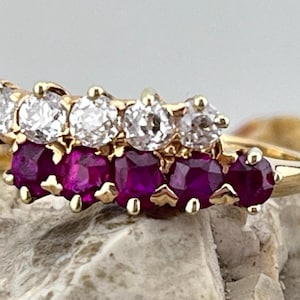 Peut inclure: Une bague en or avec une rangée de rubis ronds et une rangée de diamants ronds. La bague est sertie en forme de courbe.