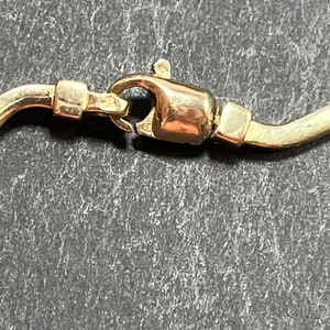 Op de afbeelding: Close-up van een gouden sluiting aan een ketting.