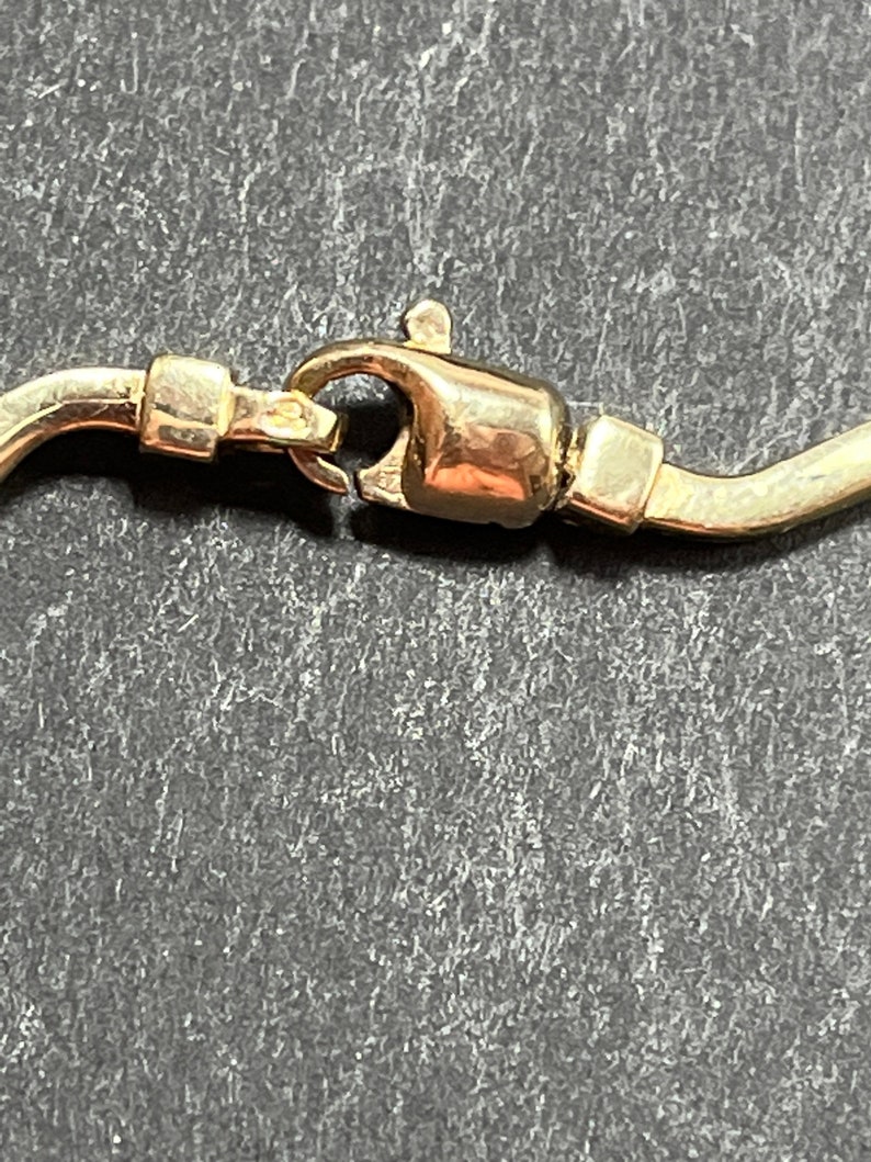 Op de afbeelding: Close-up van een gouden sluiting aan een ketting.
