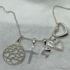 As new 5 silver pendants on a silver chain