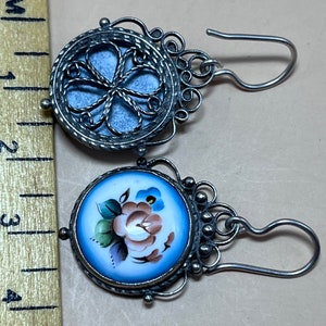 Peut inclure: Une paire de boucles d'oreilles en argent avec un motif de fleur en porcelaine bleue et blanche. Les boucles d'oreilles ont un design en filigrane et une fermeture &agrave; crochet.