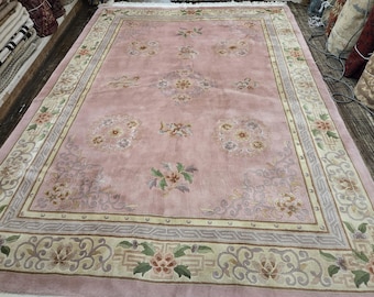 May include: A pink rug with a floral pattern and a border of beige and gray. The rug has a traditional Chinese design.