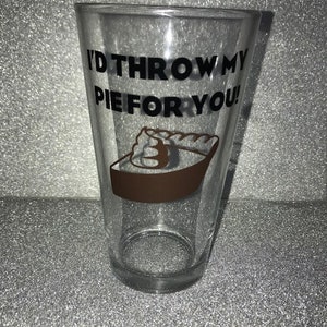 May include: A clear glass with a black and white design that says "I'd throw my pie for you!" with a brown pie graphic.