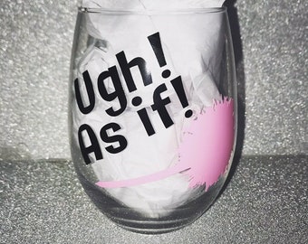 Op de afbeelding: Een helder glazen wijnglas met de tekst "Ugh! As if!" in zwarte letters en een roze verenontwerp.