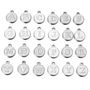 May include: A set of 26 silver-toned metal alphabet letter charms. Each charm is a circle with a white background and a black letter printed on it. The letters are in alphabetical order from A to Z.