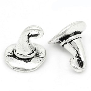 May include: Two silver-toned witch hat charms. The charms are detailed with a pointed hat and a curled brim.