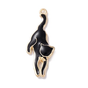 May include: A gold-toned metal cat charm with a black enamel finish. The charm depicts a cat from the rear, with its tail arched and head turned. The charm has a loop at the top for attaching to jewelry or other crafts.